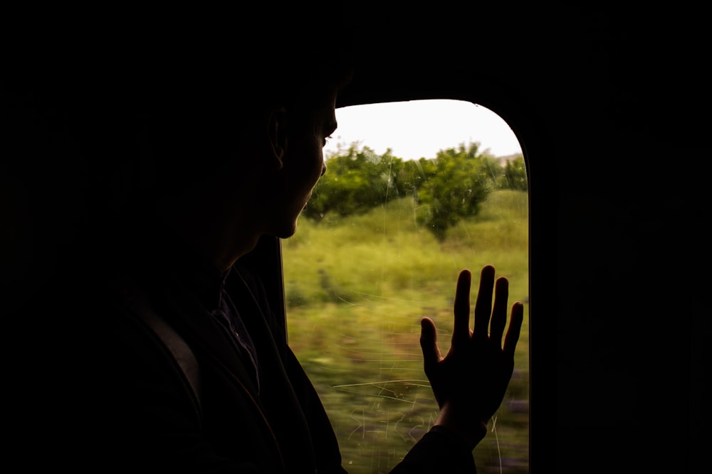 Silhouette einer Person, die auf das Fenster schaut