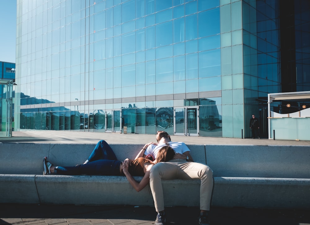 man and woman taking a nap on concrete stairs