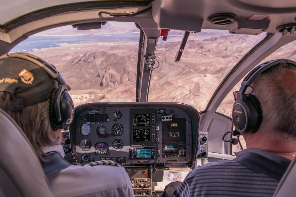 two person riding plane near mountains during daytime