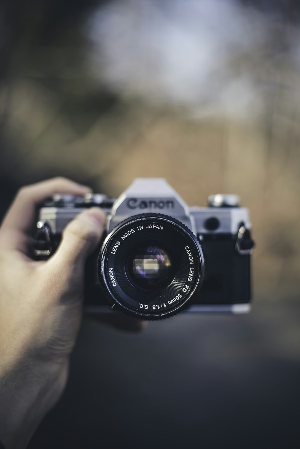 person holding black Canon DSLR camera