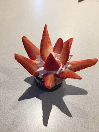 A pastel-colored layered cup cake with delicate cream swirls and fresh berries on top.