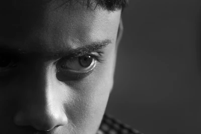 Close-up of a man’s intense eyes, showing grit and resolve, embodying the masculine edge coaching spirit.
