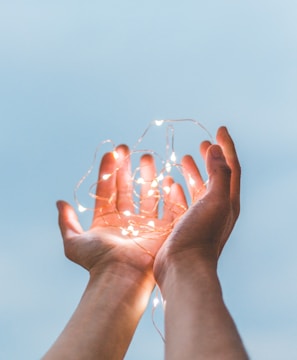 person holding string lights