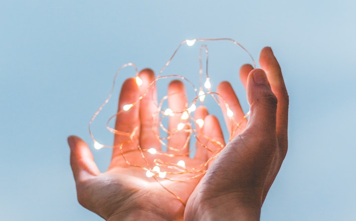 person holding string lights