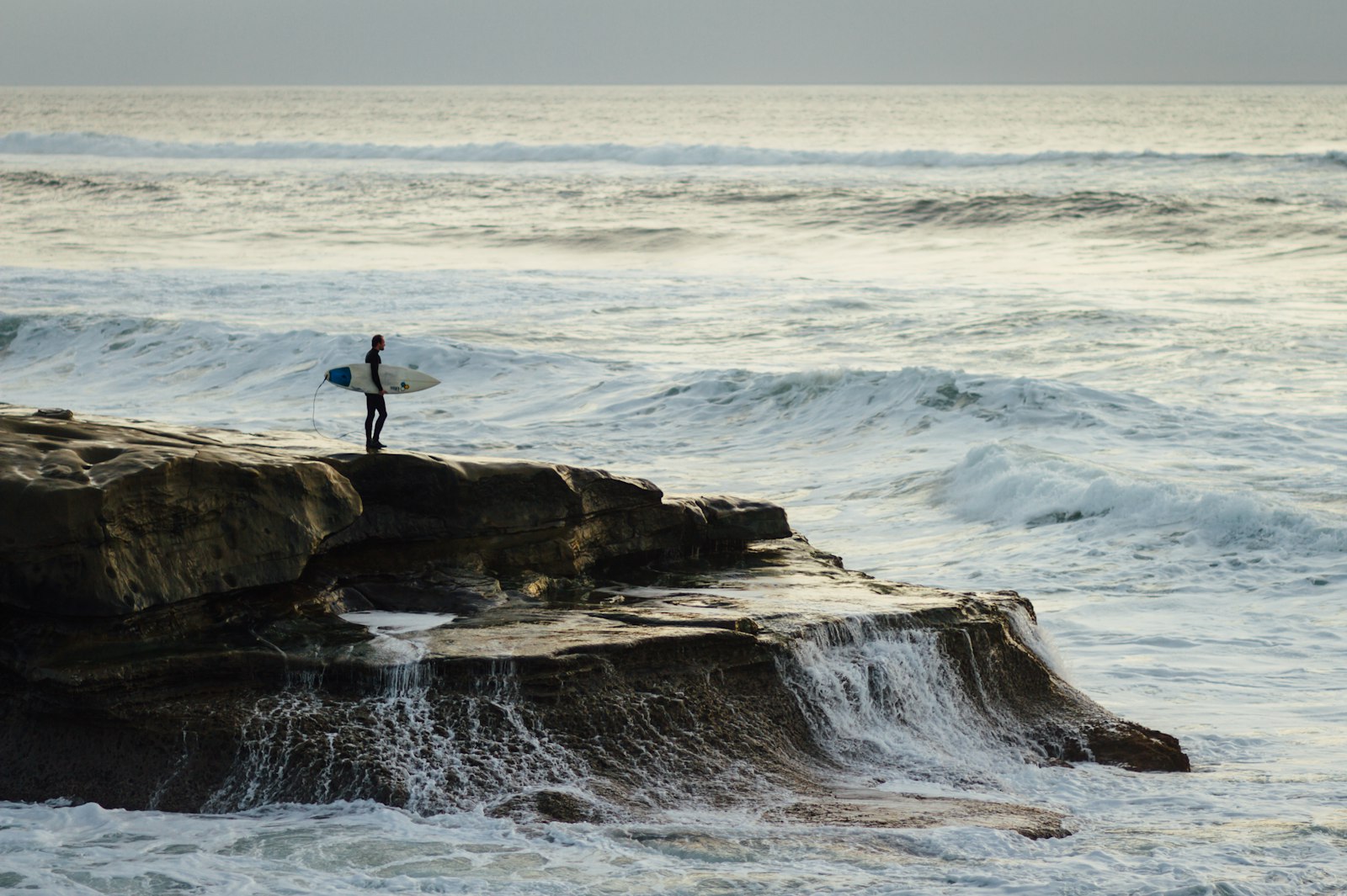 Canon EOS 7D + Canon EF 85mm F1.8 USM sample photo. Person carrying surfboard standing photography