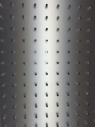 Metallic surface with evenly spaced small circular holes in a grid pattern. Light gradient transitioning from darker tones at the edges to a brighter center, giving a three-dimensional effect.