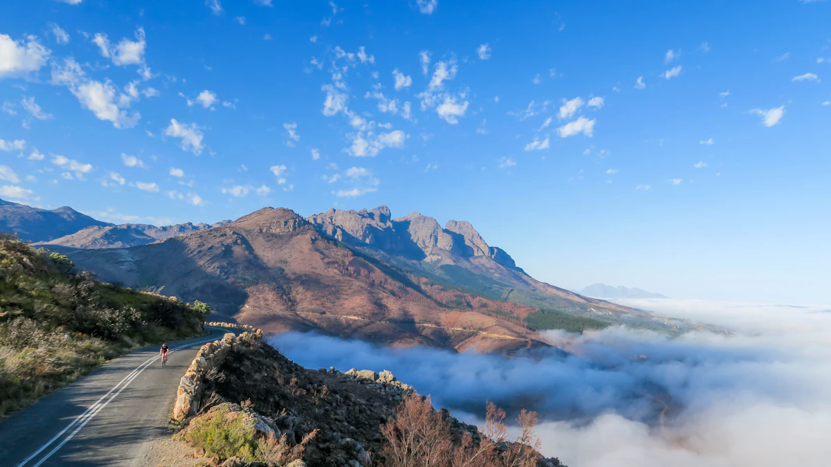 A road cyclist on a pass road near Bainskloof, Wellington, above a sea of cloud