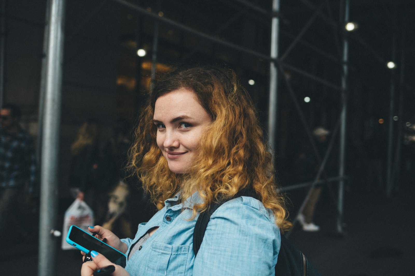 Canon EF 35mm F2 IS USM sample photo. Woman holding black smartphone photography