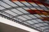 Transparent glass canopy supported by aluminum beams over an entrance.