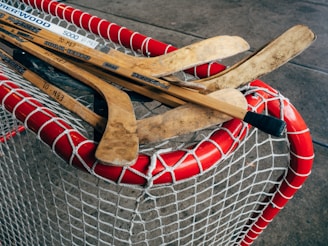 A close-up of hockey sticks crossed over a puck on the rink