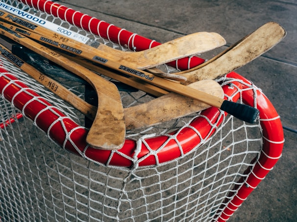 A close-up of hockey sticks crossed over a puck on the rink