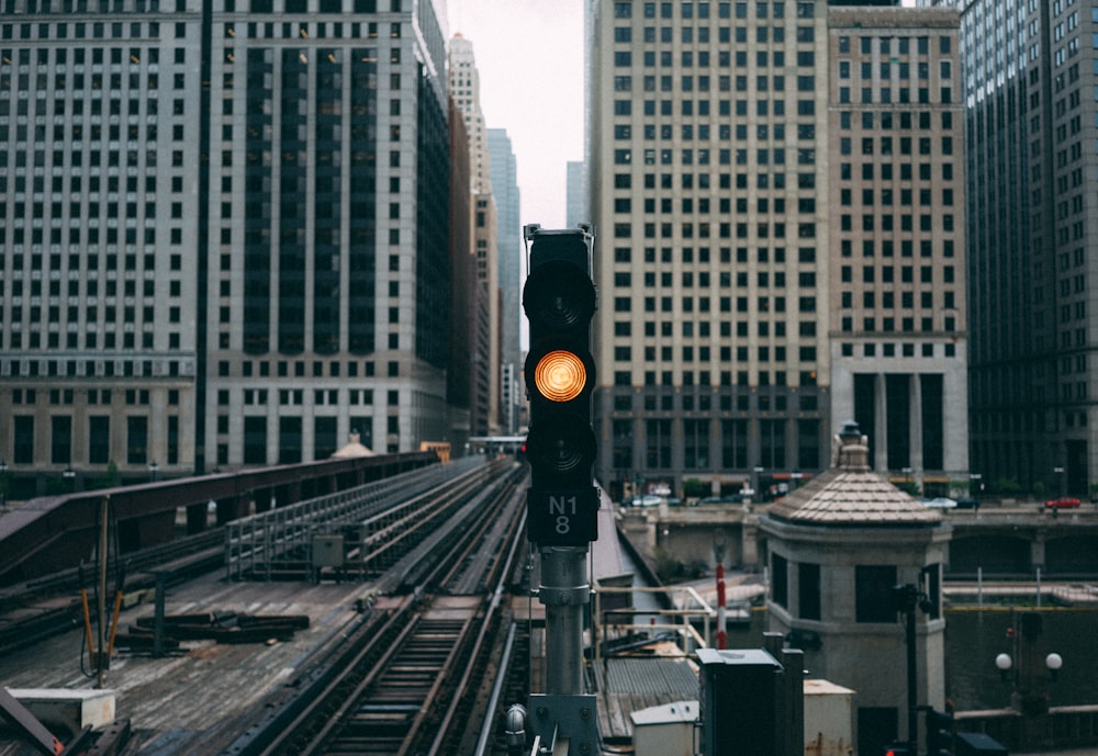 ready traffic light near railroad between buildings