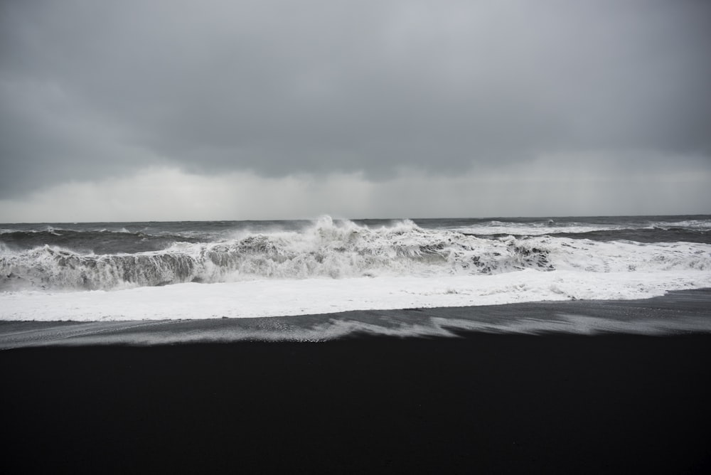 雲の下の海岸のグレースケール写真