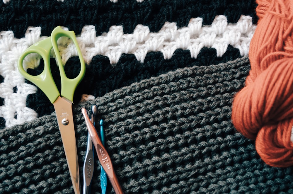 ciseaux verts en plus des bâtons à tricoter