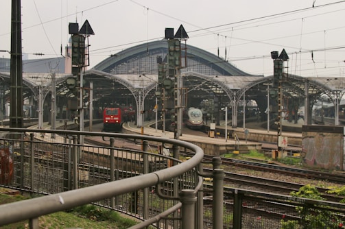 A busy railway station with multiple tracks and a modern train arriving.