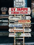 beige, red, and brown signages on beige stand at daytime