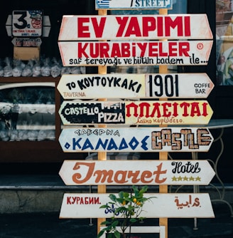 beige, red, and brown signages on beige stand at daytime