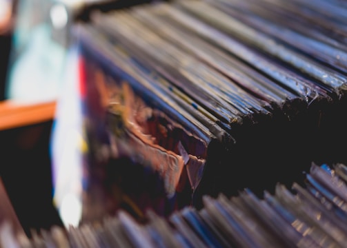 Close-up of vintage vinyl records stacked beside a microphone.