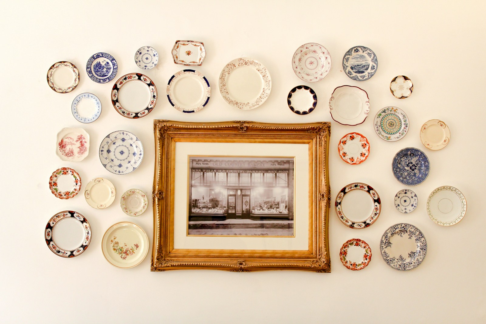 vintage plate cluster with framed art on apartment wall