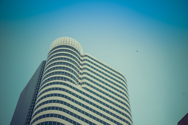A high-rise building showcasing custom metal façades and structural glass under a clear blue sky.