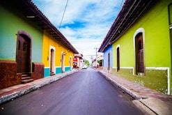 pathway of houses under blue clouds during daytime