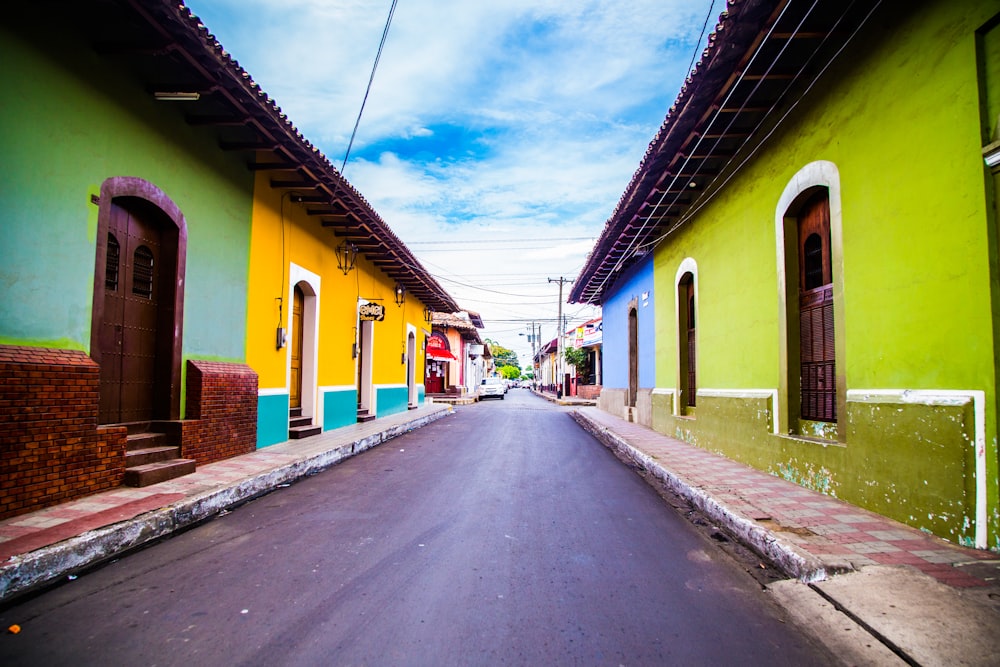 pathway of houses under blue clouds during daytime