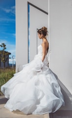 A modern bride in a sleek, minimalist wedding dress against an urban backdrop.