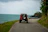 Couple enjoying a scenic drive along a coastal road in a premium SUV.