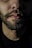 A close-up of a well-groomed beard with oil being applied.