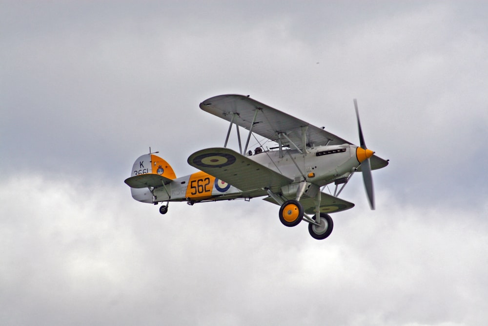 Biplan blanc et orange dans les airs