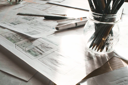 A creative workspace with sketches, notes, and story drafts scattered around.