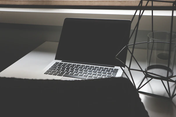 A sleek workspace with a laptop displaying wireframes and sketches, dimly lit with a modern, dark overlay.