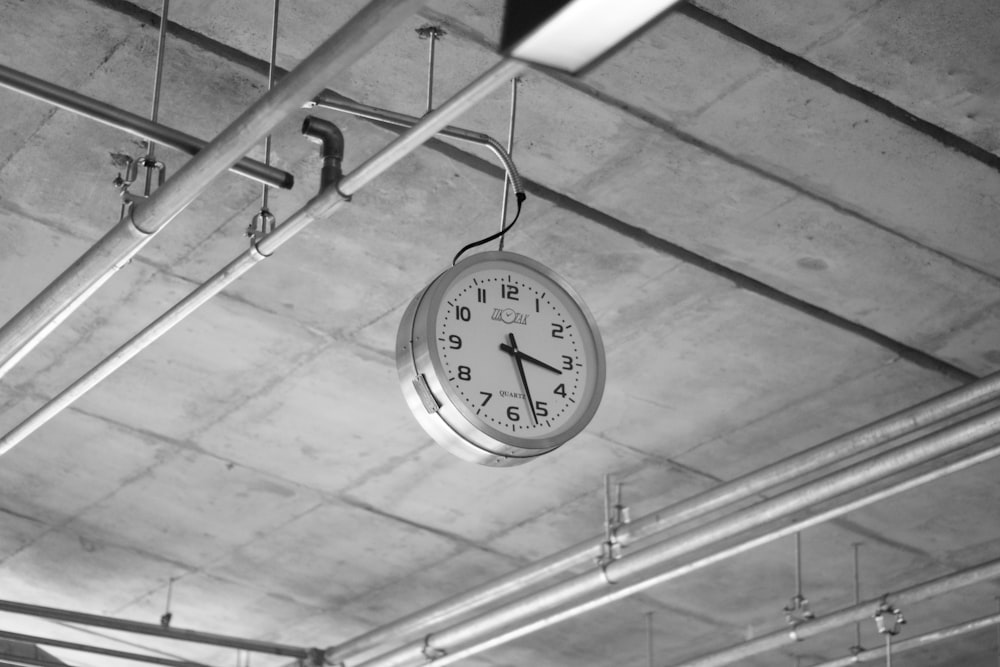 round grey stainless steel analog clock displaying 3:22