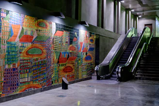 A before-and-after slider showing a dull corridor transformed with a vibrant vertical mural.