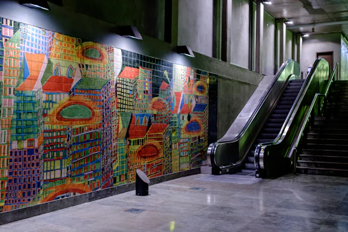 A before-and-after slider showing a dull corridor transformed with a vibrant vertical mural.