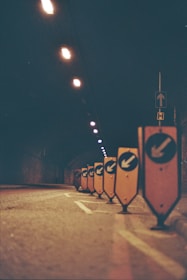 a row of street signs sitting on the side of a road