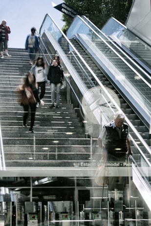 Team members of 'asude stemudancas' coordinating and carrying furniture down a flight of stairs.