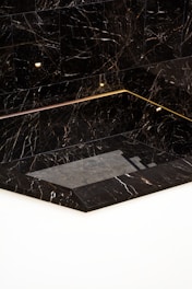 a black and white marble bathroom with gold trim