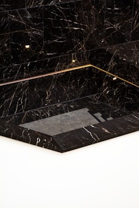a black and white marble bathroom with gold trim