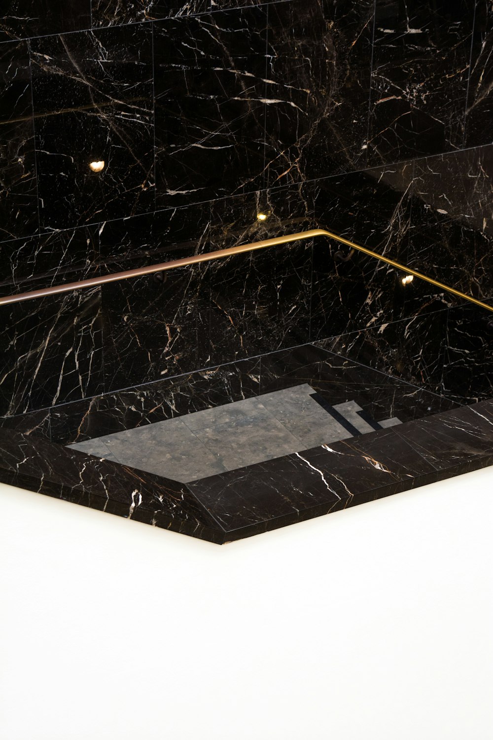 a black and white marble bathroom with gold trim