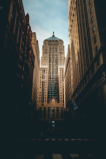 low angle photography of road straight to high-rise building under white and blue cloudy skies