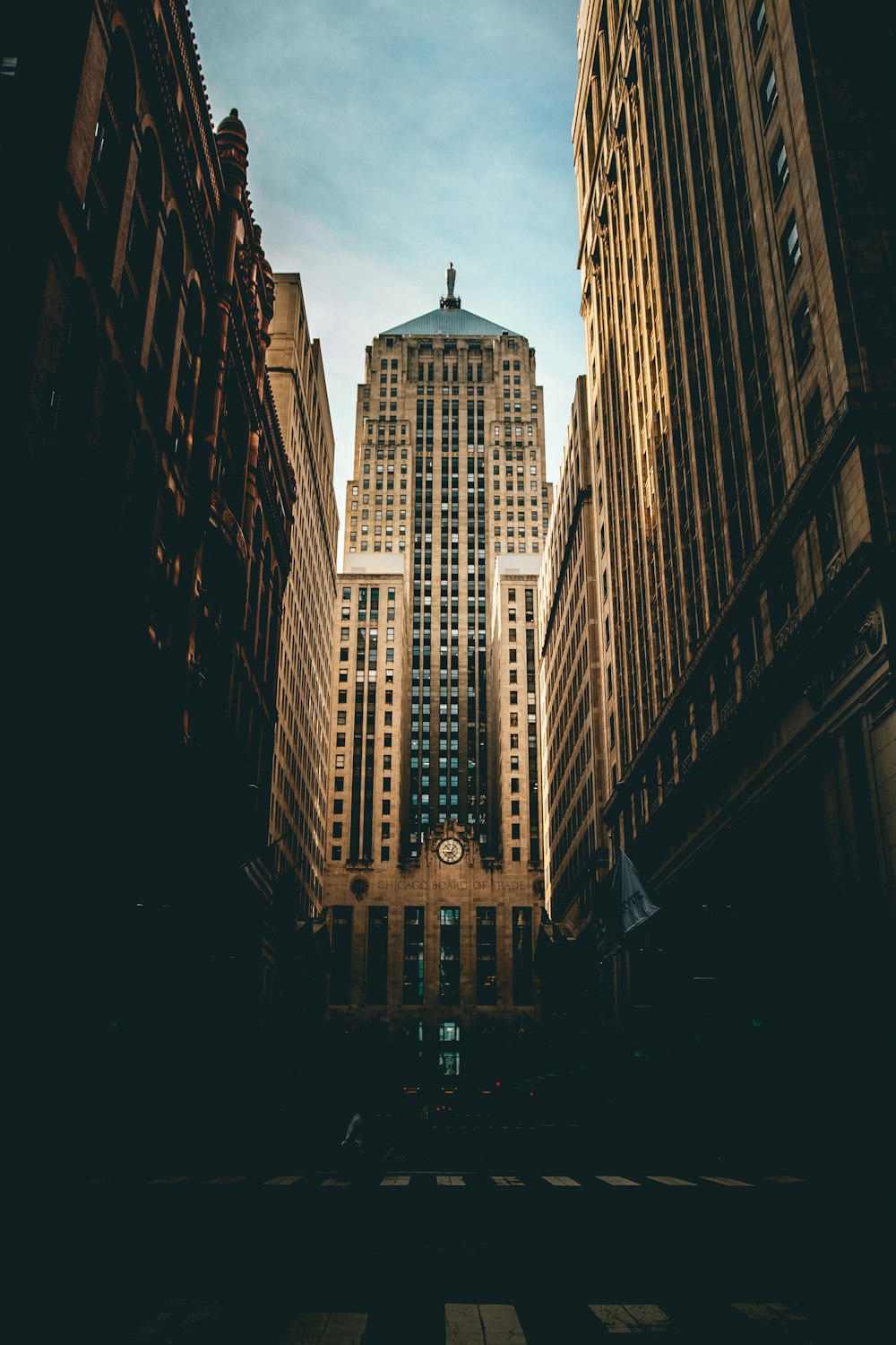 low angle photography of road straight to high-rise building under white and blue cloudy skies