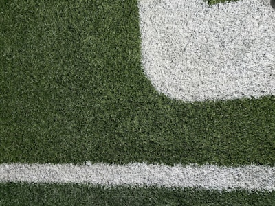 Close-up of freshly painted sports field lines with vibrant synthetic turf.