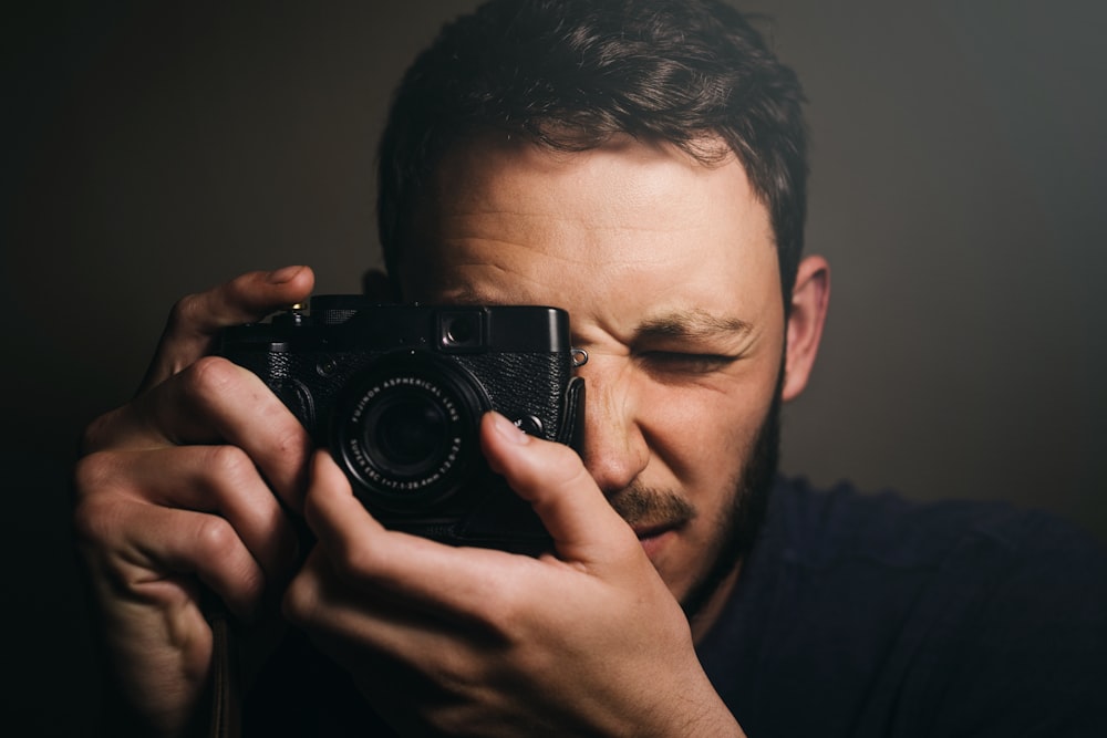 uomo che tiene la macchina fotografica