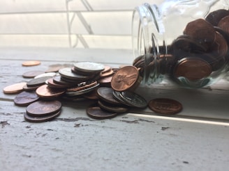 Silver coins spread out on a rustic wooden table catching the light softly.