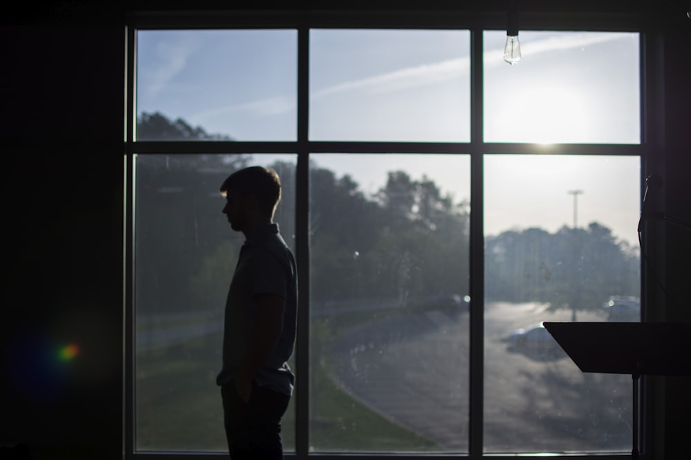 silhouette photo of man standing near mirror