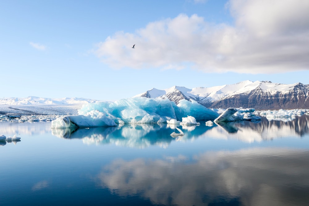 Iceberg e montagne delle Alpi di fronte a uno specchio d'acqua calmo