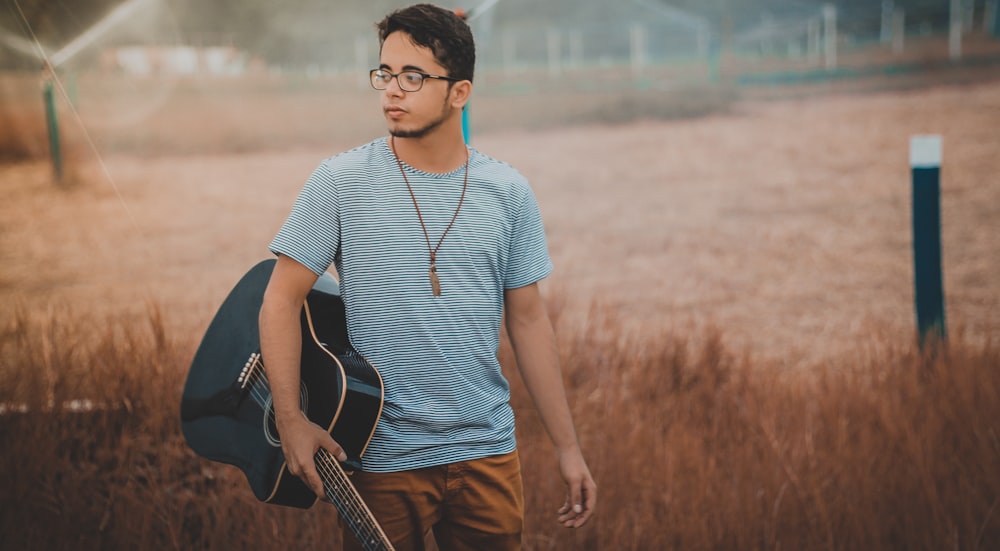 Hombre sosteniendo Cutwaya guitarra acústica