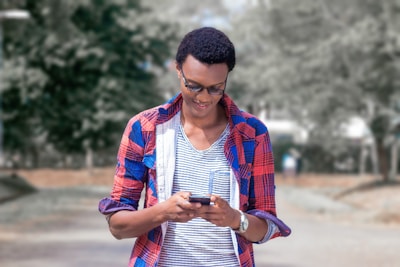 A smiling customer checking order status on a smartphone in a rural setting.