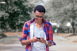 Smiling user checking side hustle options on a smartphone outdoors.
